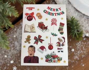 May include: A sheet of Christmas-themed stickers featuring various festive illustrations. Designs include a red bow, a gingerbread man, a teddy bear in a Santa suit, and the text "MERRY CHRISTMAS".