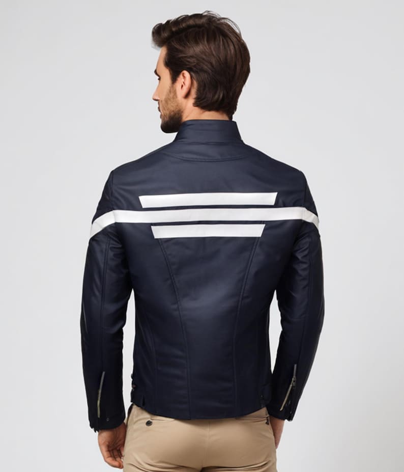 May include: Navy blue jacket with white stripes across the back and on the sleeves. The jacket has a stand-up collar and zippered sleeves. The model is wearing khaki pants. The jacket is a stylish outerwear option.