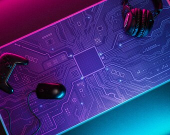 Könnte beinhalten: Ein Gaming-Setup mit einem lila und blauen Mauspad im Leiterplattendesign, einem schwarzen Gamecontroller, einer schwarzen Maus und einem Paar schwarzer Kopfhörer. Das Setup wird mit rosa und blauer Beleuchtung beleuchtet.