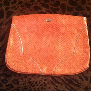 Cartera de mano con efecto piel de serpiente naranja vegana