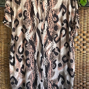 May include: A short-sleeved button-up shirt with a brown, pink, and black leopard print.