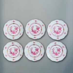 May include: Six white porcelain plates with a scalloped edge. Each plate features a central pink floral design in a basket, surrounded by gold accents and a delicate pink border. A classic and elegant tableware set.