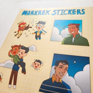 May include: A sheet of stickers featuring cartoon illustrations of characters. The stickers include images of two characters in a superhero-like pose, and other characters in various poses. The sheet has the text "MARKREX STICKERS" in blue letters.