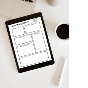 May include: A black tablet displaying an "Affirmation Prompts" template with prompts for self-reflection. The tablet is on a white surface, next to a laptop, a cup of coffee, and a pen. The template includes fill-in boxes for journaling.