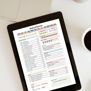 May include: A black tablet displaying a "Daily Planner" template with sections for weather, schedule, productivity, and water intake. The planner includes a habit tracker, to-do list, and a section for meals and exercise.