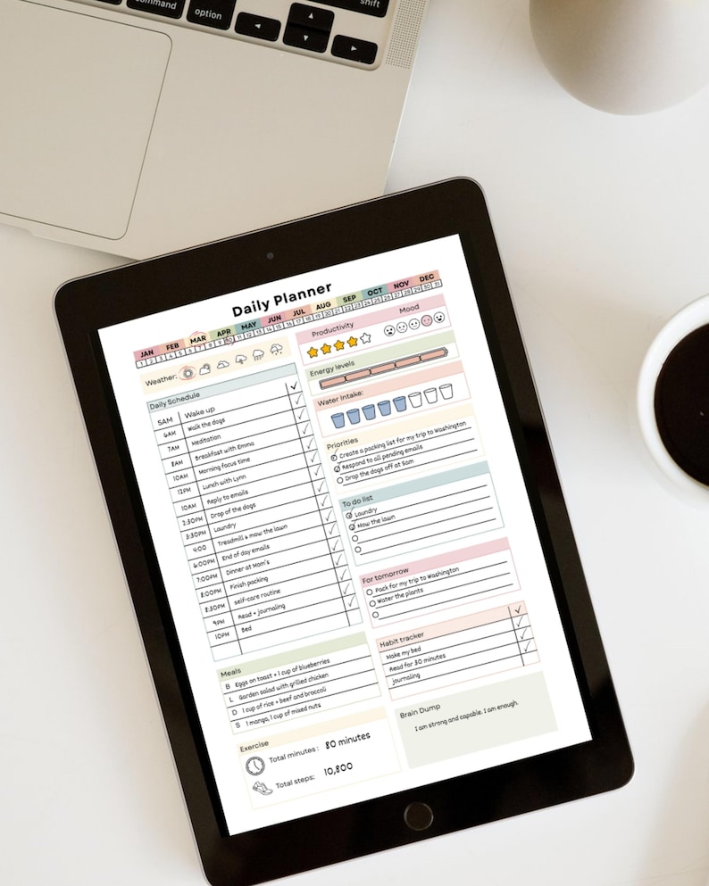 May include: A black tablet displaying a "Daily Planner" template with sections for weather, schedule, productivity, and water intake. The planner includes a habit tracker, to-do list, and a section for meals and exercise.