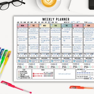 May include: A white weekly planner with a detailed meal plan for each day of the week, including water intake and vitamin tracking. Colorful pens and a cup of coffee are on the table. The planner includes the year 2025.