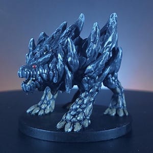 May include: A detailed miniature figurine of a fantasy creature. The figure is primarily dark grey with textured, spiky protrusions and accents of a lighter colour on the paws. The creature has red eyes and an open mouth.