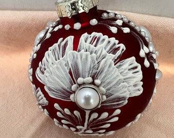 Deep red glass Christmas ornament,glass,I used a white mud and when dried it’s raised,pearls around side and on flower,snowflakes other side