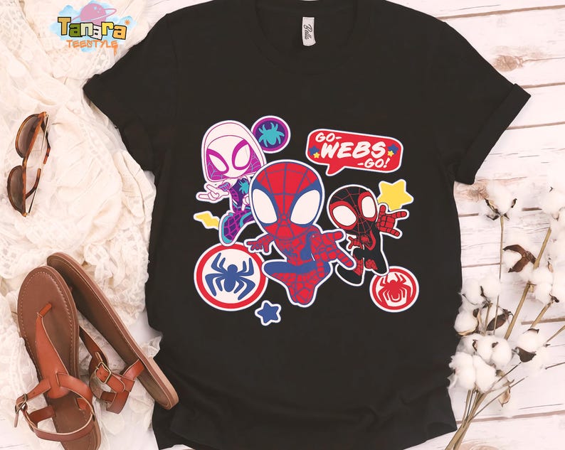 May include: Black t-shirt featuring a colorful graphic of Spider-Man characters. The design includes Spider-Gwen, Spider-Man, and Miles Morales, with the text "GO-WEBS-GO!". The graphic is surrounded by spider web and star accents.