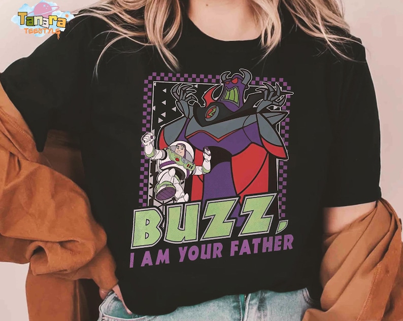 May include: Black t-shirt with a graphic of Buzz Lightyear and Zurg from Toy Story. The design includes the text "BUZZ. I AM YOUR FATHER" in green and white. The image has a purple and black checkered border.