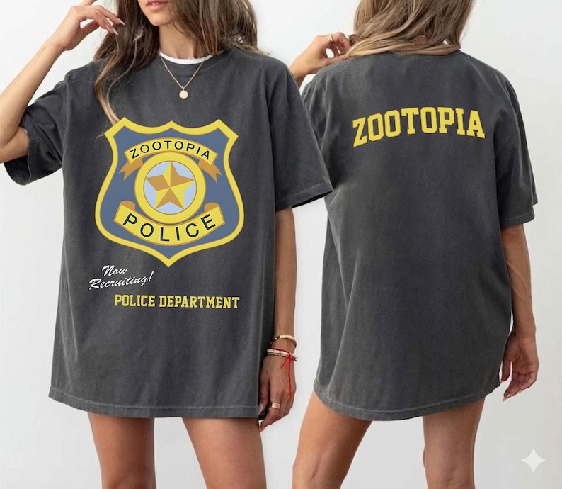May include: Dark gray t-shirt featuring a Zootopia Police Department badge graphic on the front and the word "ZOOTOPIA" on the back. The front graphic includes the text "Now Recruiting!" and "POLICE DEPARTMENT".