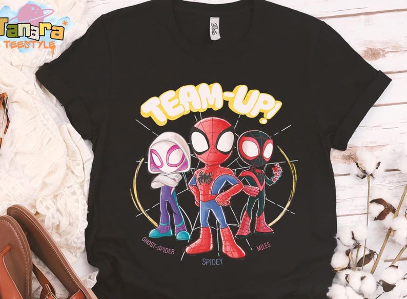 May include: Black t-shirt featuring a cartoon graphic of Spider-Man, Spider-Gwen, and Miles Morales with the words "TEAM-UP!". The characters are in their superhero costumes, with the names "Ghost-Spider", "Spidey", and "Miles" below them.
