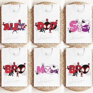 Puede incluir: Camisetas blancas con dise&ntilde;os gr&aacute;ficos coloridos con personajes de Spider-Man y nombres como "ALEX", "DAD", "SO", "BRO", "MOM" y "BRO". Cada dise&ntilde;o incluye una telara&ntilde;a y varias figuras de Spider-Man.