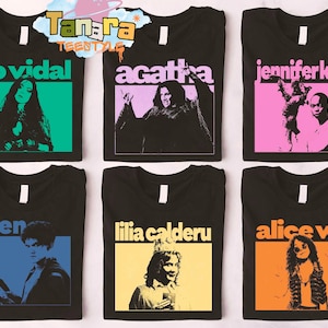 May include: Black t-shirts with colorful graphic designs. Each shirt features a name in a bold font above a stylized image of a person. The names include "rio vidal", "agatha", "jennifer kale", "teen", "lilia calderu", and "alice wu".