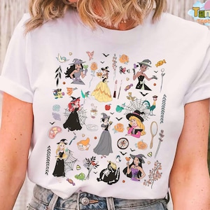 May include: White t-shirt featuring a colorful Halloween-themed graphic. The design includes illustrations of witches, bats, roses, and other spooky elements. The text "Tanara Teestyles" is printed on the top right corner.