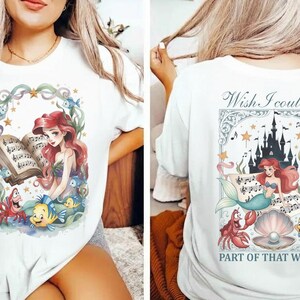 May include: White t-shirt featuring a colorful illustration of a mermaid reading sheet music, surrounded by sea creatures. The back of the shirt has a matching design with the text "Wish I could be part of that world."