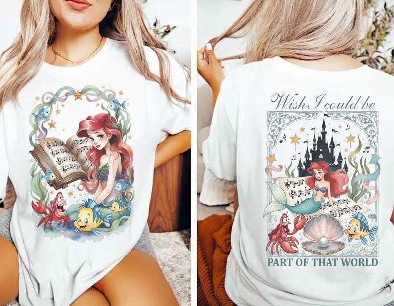 May include: White t-shirt featuring a colorful illustration of a mermaid reading sheet music, surrounded by sea creatures. The back of the shirt has a matching design with the text "Wish I could be part of that world."