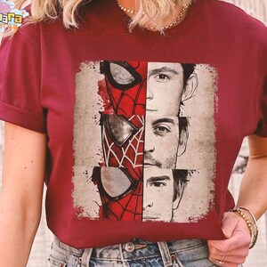 Puede incluir: Camiseta burdeos con un gr&aacute;fico de la m&aacute;scara de Spider-Man y los rostros de tres actores que han interpretado al personaje. El dise&ntilde;o es en rojo, blanco y negro, con un estilo vintage desgastado.