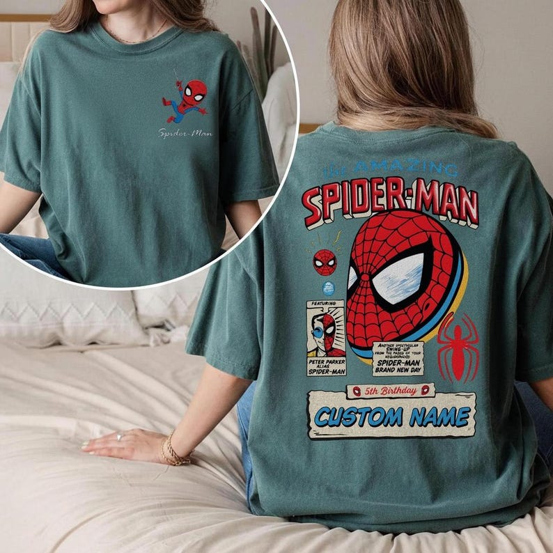 Puede incluir: Camiseta de color verde azulado con gr&aacute;ficos de Spider-Man. La parte delantera muestra un peque&ntilde;o dibujo animado de Spider-Man, y la parte trasera presenta un gran dise&ntilde;o de m&aacute;scara de Spider-Man con el texto "The Amazing Spider-Man".