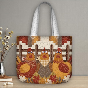 May include: A quilted tote bag featuring three cartoon chickens in front of a wooden fence. The chickens are in shades of orange, brown, and tan, with leaf accents. The bag has a white quilted handle.
