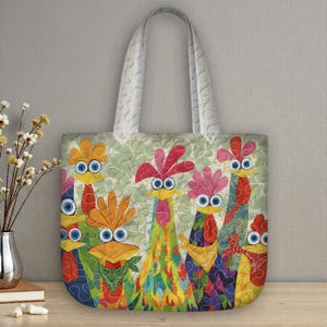 May include: A quilted tote bag with a vibrant rooster design. The bag has a light green background with a repeating pattern. The rooster illustrations are in various colours, including red, orange, yellow, and blue. The handles are white.