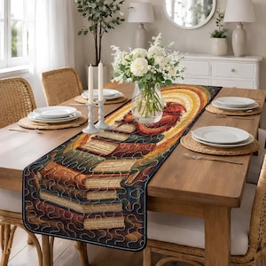 May include: A rectangular table runner featuring a stack of books with a red dragon illustration. The runner has a black border and is placed on a wooden table set for a meal. The runner's design includes shades of brown, orange, and green.
