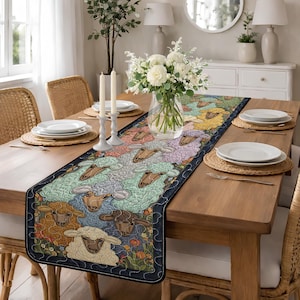 May include: A colorful table runner featuring a pattern of sheep in various colors, including yellow, green, and brown. The runner is placed on a wooden table, with plates, candles, and a vase of flowers. The edges are trimmed with a dark blue border.