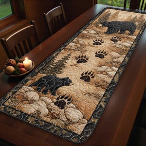 May include: A rectangular table runner featuring a bear and paw print design. The runner has a brown and tan background with a black border. Two black bears are depicted, along with several bear paw prints.