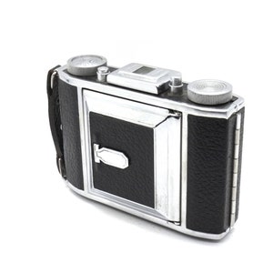 May include: A vintage silver and black 35mm film camera with a leather covering. The camera has a built-in flash and a viewfinder.