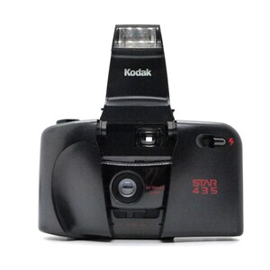 May include: A black Kodak Star 435 film camera with a built-in flash. The camera has a red "EXTREME ZOOM" label and a red "STAR 435" label.