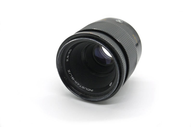 K&ouml;nnte beinhalten: Ein schwarzes Industar-50-2 Objektiv mit einer Brennweite von 50 mm und einer maximalen Blende von f/2,8. Das Objektiv ist f&uuml;r 35-mm-Filmkameras ausgelegt.