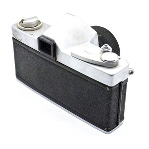 May include: A silver and black 35mm film camera with a black leather covering. The camera has a silver top with a black viewfinder and a silver lens cap.