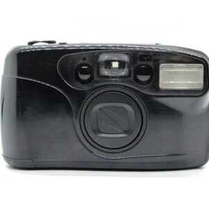 May include: A black point-and-shoot film camera with a built-in flash. The camera has a lens, flash, and viewfinder. The camera is on a white background. The camera is a vintage style.