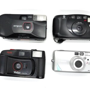 Puede incluir: Cuatro c&aacute;maras de pel&iacute;cula diferentes, incluyendo una Argus negra, una Vivitar PS10 negra, una Minolta Riva Zoom PCO negra y una Canon plateada con una lente Zeiss.