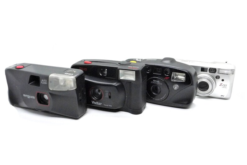 Puede incluir: Cuatro c&aacute;maras de pel&iacute;cula compactas diferentes, que incluyen una Argus negra, una Vivitar negra, una Minolta negra y una Ziss plateada. Las c&aacute;maras est&aacute;n en buen estado y tienen una variedad de funciones.