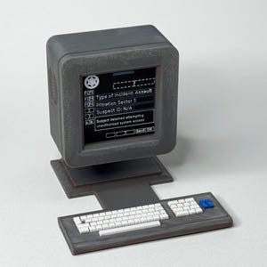 Peut inclure: Un ordinateur rétro gris avec un petit écran affichant du texte et un clavier assorti. L'écran affiche du texte tel que "Type of Incident: Assault" et "Suspect ID: N/A". Le clavier a des touches blanches et un bouton bleu.