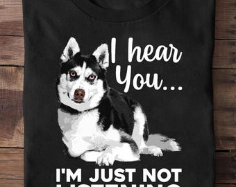 May include: Black t-shirt featuring a Siberian Husky dog illustration with the text "I hear You... I'M JUST NOT LISTENING" in white. The dog is black and white with brown eyes and a pink nose.