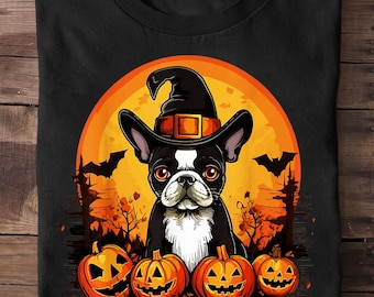 Puede incluir: Camiseta negra con un diseño de Halloween. Presenta un Boston Terrier con un sombrero de bruja, sobre un fondo de luna llena naranja. El diseño incluye calabazas talladas, murciélagos y siluetas de árboles.
