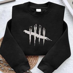 May include: Black crew neck sweatshirt with a white graphic. The graphic is a series of vertical lines with dripping details, joined by a horizontal stroke. The sweatshirt is made of a soft material and is suitable for casual wear.