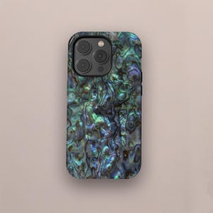 May include: A smartphone case with an iridescent, pearlescent design. The case features a swirling pattern of blues, greens, and browns, creating a natural, organic look. The case has a camera cutout with three lenses.