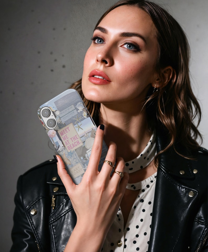 May include: A phone case with a collage of images and text, including the words "Meet me at the beach". The case is being held by a person wearing a black leather jacket and a white polka dot shirt.