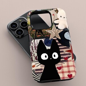 May include: A black phone case featuring a cartoon black cat with white eyes and whiskers. The case has a collage design with a teddy bear, vinyl record, and red hearts. The background includes text and a red and white checkered pattern.