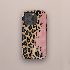 May include: A phone case with a gold and black leopard print pattern on the left side and a pink, textured design on the right. The case has a glossy finish and a camera cutout.