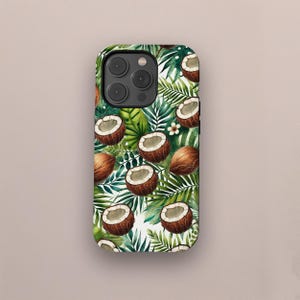以下が含まれることがあります： ココナッツと緑のヤシの葉のトロピカル柄の携帯電話ケース。ココナッツは茶色と白で、水彩画風です。背景は白で、鮮やかで夏らしいデザインです。