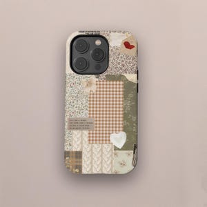 Pode incluir: Uma capa de telefone com um design de patchwork com vários padrões e texturas. A capa inclui estampas florais, xadrez e texto, com um coração e um laço. A paleta de cores é principalmente bege, castanho e verde.