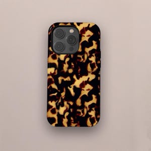 May include: A smartphone case with a tortoiseshell pattern. The case has a glossy finish and a repeating pattern of dark brown and golden-yellow shapes. The case has a camera cutout with three lenses and a flash.