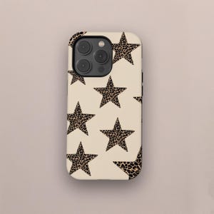 May include: A phone case with a cream-colored background and a repeating pattern of leopard print stars. The case has a camera cutout and buttons for volume and power.