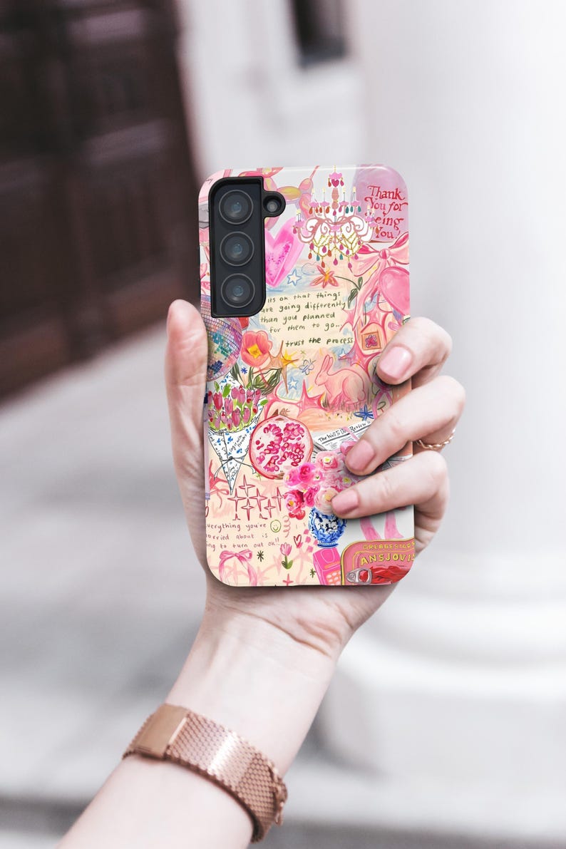May include: A phone case with a colorful, whimsical design. The case features a collage of pink and white illustrations, including flowers, a rabbit, and text that reads "Thank You for being You" and "trust the process."