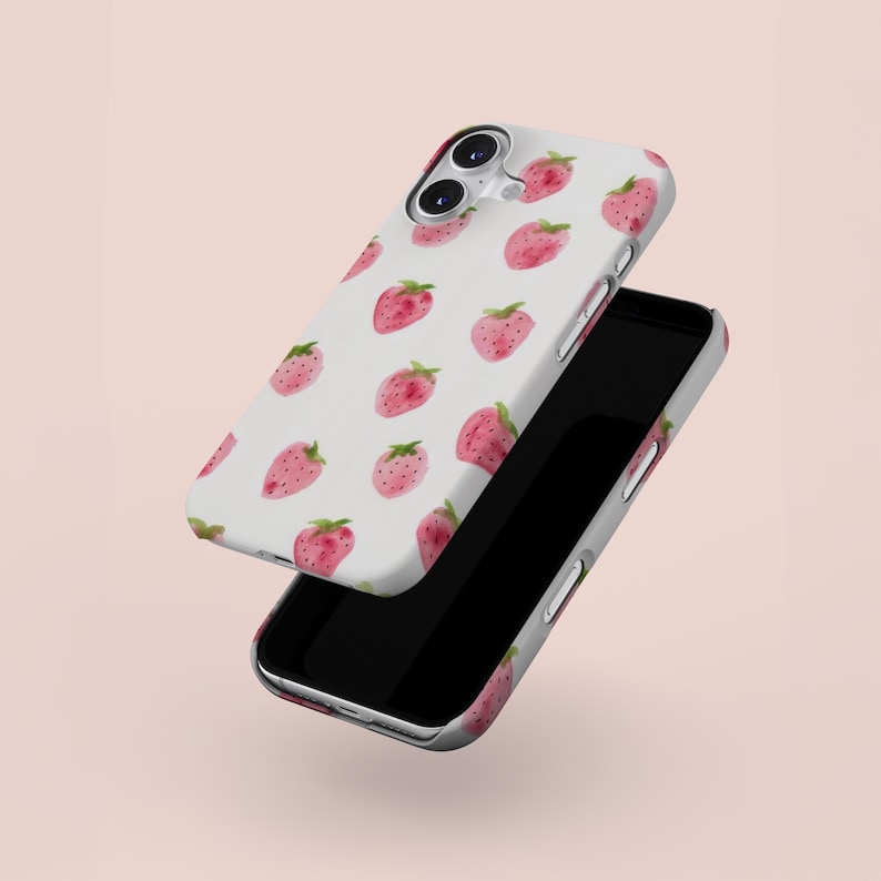 May include: White phone case with a pattern of pink watercolor strawberries with green leaves. The phone case is shown with a black smartphone, with the case slightly offset from the phone.